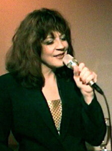 Laurel Massé singing into a microphone