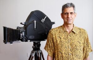 Michael Reano standing next to a film camera