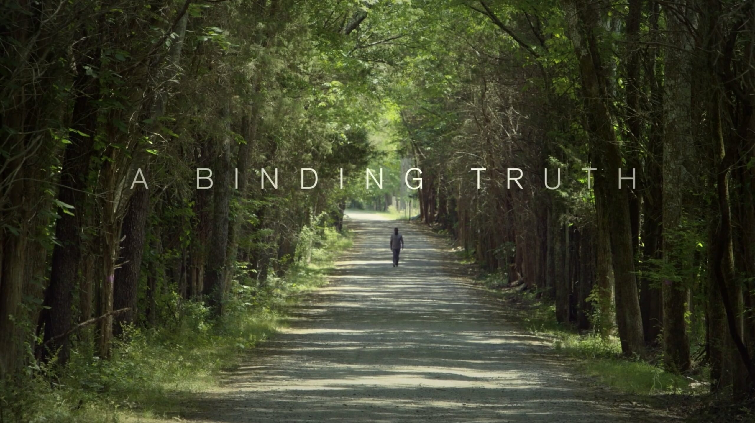 Title text "A Binding Truth". A man walking down a dirt path parted through tall trees on each side.