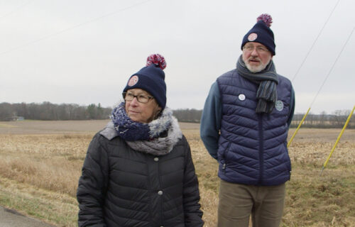 The Wetterling's standing on a roadside with a large field in the background