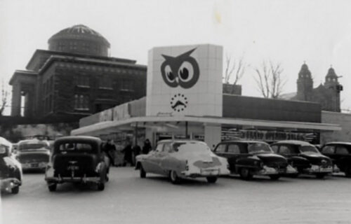 A Red Owl grocery store with several cars parked in front