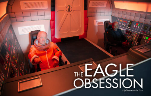 Jeffrey Morris and Nick Tate dressed in an astronaut suit sitting in The Eagle replica.